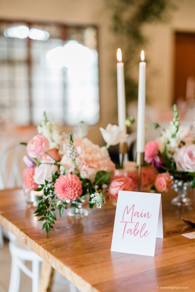 main-table-sign-with-blush-and-coral-flowers